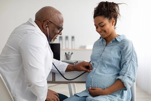 Pregnant woman talking to a seasoned male physician
